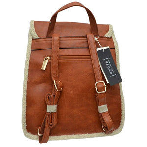 Brown Faux Shearling Trimmed Vegan Leather Foldover Backpack. This stylish bag features an elegant faux shearling trim and a back pocket for extra versatility. The faux shearling trim provides a pleasant and luxurious feel to the bag. It is perfect for carrying your daily essentials, from books to work essentials.