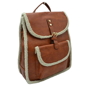 Brown Faux Shearling Trimmed Vegan Leather Foldover Backpack. This stylish bag features an elegant faux shearling trim and a back pocket for extra versatility. The faux shearling trim provides a pleasant and luxurious feel to the bag. It is perfect for carrying your daily essentials, from books to work essentials.