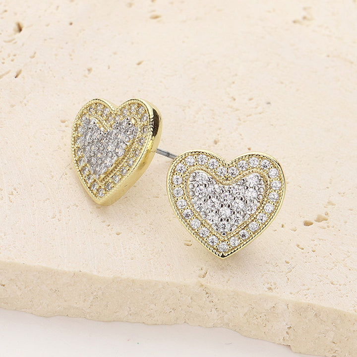 14K Gold Plated CZ Stone Paved Heart Stud Earrings are the perfect addition to any jewelry collection. The stunning heart-shaped design is accented with sparkling cubic zirconia stones, adding a touch of glamour to any outfit. Made with high-quality materials, these earrings are both durable and stylish, making them a must-have for any fashion-forward individual. 