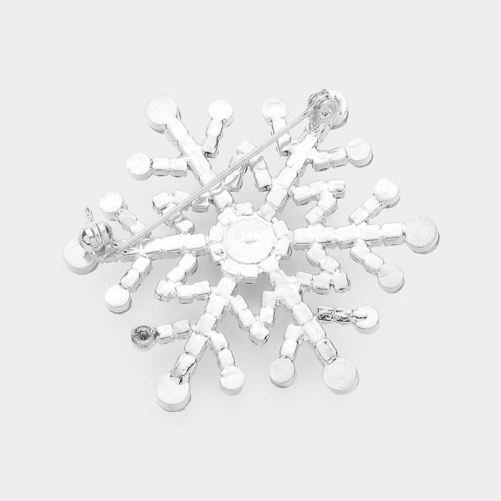 Elegant snowflake brooch pin adorned with sparkling rhinestones in a dazzling winter design. Perfect accessory for coats, scarves, and holiday outfits, adding festive sparkle and seasonal charm to any look. A perfect gift for Christmas.