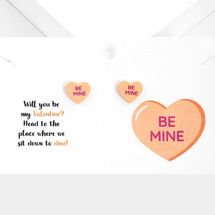 Be Mine Message Heart Stud Earrings are a charming way to express your love. Expertly crafted, these intricately designed hearts feature the words 'Be Mine' elegantly etched into them. Made with high-quality materials, these earrings are the perfect gift to show your affection. 