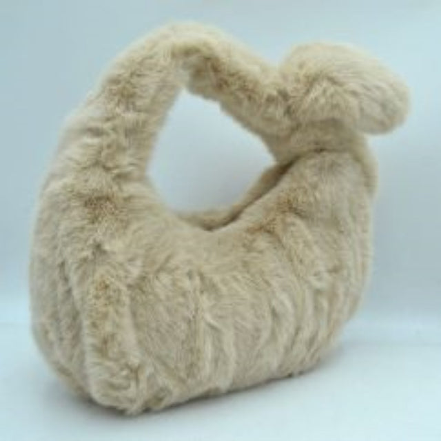 Beige This unique handbag features a fluffy, plush texture across its entire exterior, offering a soft and tactile finish for distinctive everyday use. It showcases a slouchy, curved silhouette highlighted by an integrated top handle that features a prominent twist knot detail on one side. The open-top design allows for quick and convenient access to the main storage compartment, making it a playful yet functional accessory for carrying your daily essentials.