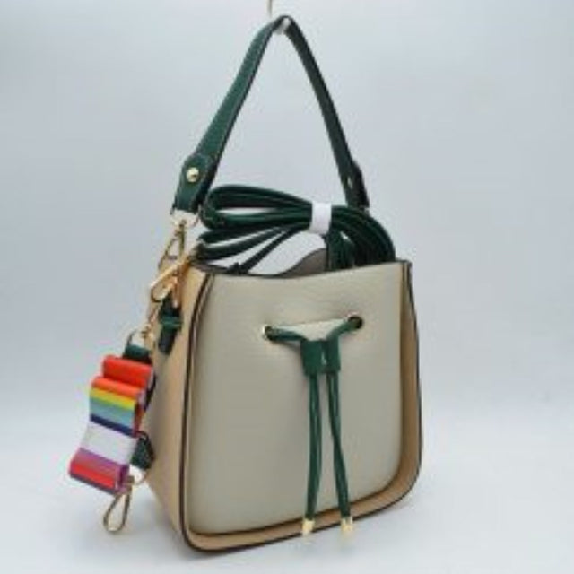 Beige This stylish bucket bag features a distinctive color-blocked design crafted with a pebbled exterior texture, making it a versatile accessory for everyday use. The front panel includes a classic cinch drawstring closure detailed with contrasting trim and polished metallic aglets that open to a secure main storage compartment. Built for flexibility, it is equipped with a structured shoulder handle, an adjustable long shoulder strap