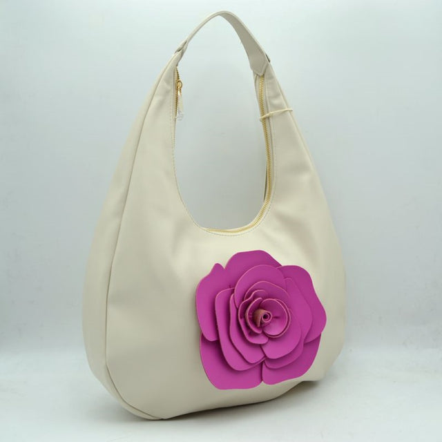 Beige This stylish hobo shoulder bag features a smooth exterior finish with a relaxed, slouchy silhouette that is perfect for everyday use. A striking, dimensional layered flower applique accents the front panel, providing a distinct focal point. Designed with practicality in mind, the bag is equipped with a wide integrated shoulder strap that curves seamlessly into the body, opening up to a spacious storage compartment secured by a prominent top zipper closure with a metallic pull.
