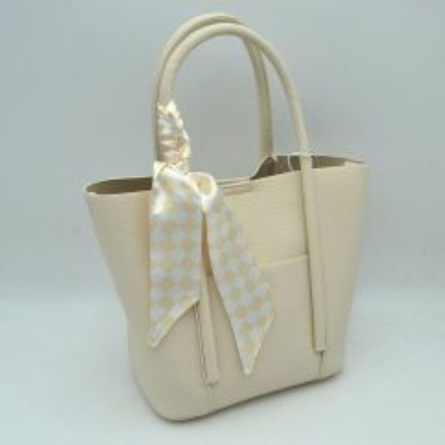 Beige Elevate your everyday style with this chic and highly functional tote bag. Crafted with a premium pebbled exterior finish, this structured handbag offers a sophisticated texture that handles daily wear with ease. The front features a convenient open slip pocket secured by a matching central snap closure, providing quick access to small essentials. Adding a modern, graphic contrast, a silky checkered pattern scarf comes beautifully wrapped and tied along the front handle base. 