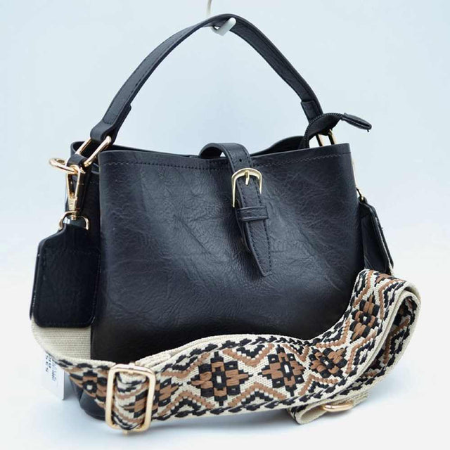 Black Designed for stylish everyday use, this versatile bag features a textured finish with a central decorative buckle strap across the open top. It offers multiple carrying options, including a sturdy top handle and a wide, removable shoulder strap showcasing a detailed geometric woven pattern. Complete w/ secure metal hardware clasps and an adjustable slide buckle on the patterned strap, this spacious bag blends practical storage compartments w/ a modern aesthetic for convenient hands-free styling.
