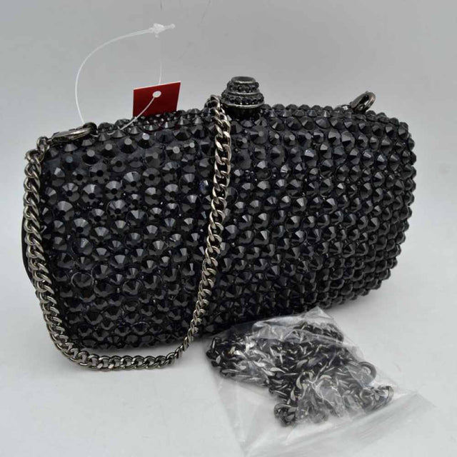 Black This structured clutch bag features a heavily embellished exterior covered in rows of faceted, multi-dimensional studs that create a textured look suitable for elevated everyday styling or evening events. The compact design opens to a main storage compartment via a secure rigid frame and an ornamental, cylindrical top clasp set with matching small accents. For versatile carrying options, the piece is equipped with a metallic curb chain handle attached to top loop connectors