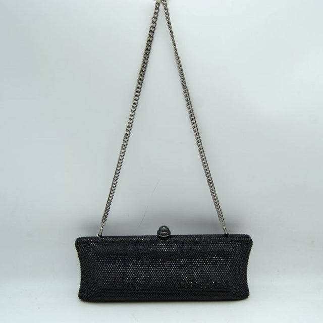 Black This structured clutch bag features an elongated silhouette with subtly flared edges, completely covered in fine, glittering micro-embellishments that create a shimmering, textured surface suitable for elegant everyday use. The central storage compartment is securely accessed via a hard-frame opening with an ornamental, rounded top clasp. A long, slender metallic curb chain strap is permanently attached to the top loops
