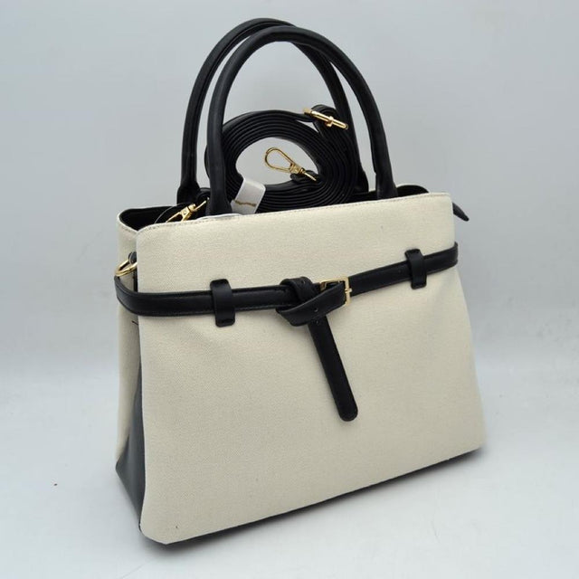 Black Elevate your daily wardrobe with this sophisticated belted satchel. Combining the relaxed texture of a woven canvas body with the structure of sleek faux-leather trim, this handbag brings a tailored, high-end feel to any look. Perfect for professional environments, travel, or upscale weekend outings, its clean silhouette and distinctive knotted belt accent make it a timeless choice for the modern wardrobe.