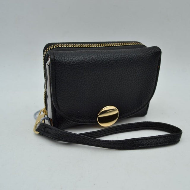 Blac This compact everyday wallet features a pebbled, textured exterior designed for practical multi-compartment storage. It includes a secure, top zip-around section with metallic teeth alongside a front fold-over flap portion accented by a prominent round metallic button closure. For convenient carrying during daily errands, it comes equipped with a slim, matching wristlet strap attached to the side hardware.