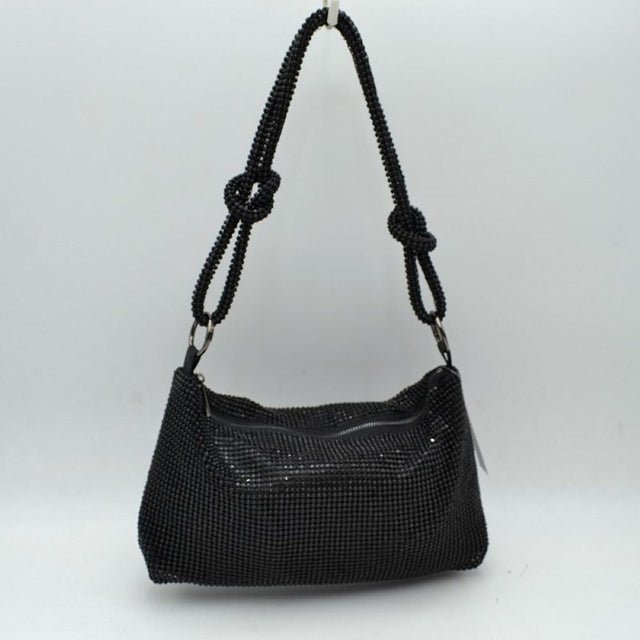 Black This shoulder bag features a textured grid exterior suitable for versatile everyday use. It includes a main storage compartment accessible via a top zipper closure to keep personal items secure. The bag is completed by a matching textured shoulder strap that features integrated decorative knots on each side and connects to the main body through circular rings.