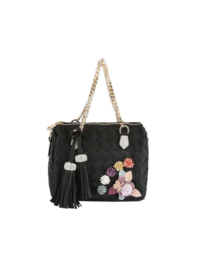 Black This structured shoulder bag features a quilted diamond pattern across the exterior, enhanced by an arrangement of dimensional floral accents on the front panel. Designed with dual woven chain handles that secure to metallic hardware loops, it offers an elegant option for everyday use or special occasions. A secure top zipper closure opens to the main storage compartment, which is stylishly accessorized with two large hanging tassels attached to the side handle base.