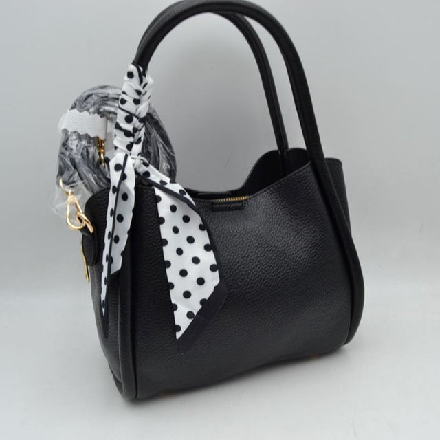Black Add a touch of retro sophistication to your everyday look with this beautifully contoured satchel handbag. Designed with a structured yet softly curved silhouette, this bag features a premium pebble-textured finish that resists daily wear while maintaining a polished aesthetic. The side handle is playfully wrapped with a removable black-and-white polka dot scarf, lending a timeless, feminine charm to the overall piece.