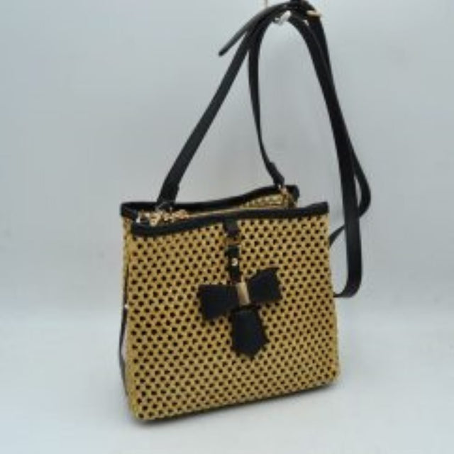 Black This structural crossbody bag features an intricate, open-weave mesh pattern across its body, offering an eye-catching and distinctive look for everyday use. A contrasting central vertical tab on the front panel is highlighted by a structured decorative bow accent anchored with metallic hardware. Built for easy organization, the bag contains multiple secure storage compartments including dual top zippers, while a long, adjustable slim shoulder strap loops smoothly over the top to provide comfortable