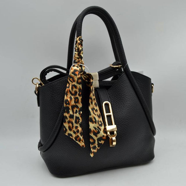 Black This elegant everyday handbag features a textured pebbled body with a structured silhouette and a curved top opening. It offers versatile carrying options with its dual rounded top handles and a detachable, adjustable shoulder strap connected via gold-toned metal hardware. A central strap closure with a distinctive elongated metallic turn-lock clasp secures the main storage compartment