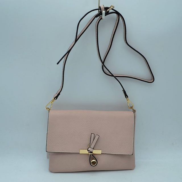Blush This versatile handbag features a textured finish with a clean foldover flap design, perfect for stylish everyday wear. The front closure is accented with a unique knotted strap detail paired with a polished metallic slider and charm. Designed with a slim profile, it includes a long, adjustable shoulder strap attached via metallic clasps for comfortable hands-free crossbody or shoulder carrying.