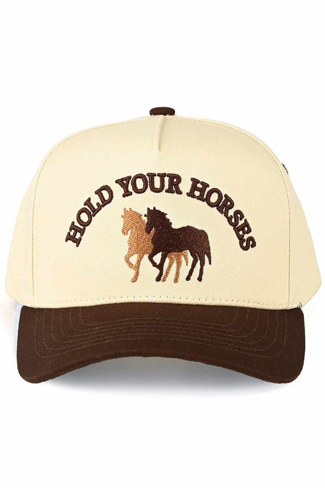 Brown Classic two-tone trucker hat featuring bold "HOLD YOUR HORSES" embroidered lettering. Crafted from 100% cotton for breathable comfort all day long. Snap back closure adjusts to fit most head sizes with a circumference of 22.5". Structured design with mesh panels keeps you cool. Perfect for casual wear, outdoor adventures, or adding personality to any outfit.&nbsp;