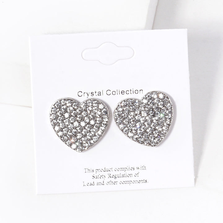 Clear-Rhodium-Crystal Stone Paved Heart Stud Earrings feature a sparkling design that adds a touch of elegance to any outfit. Crafted with expert precision and quality materials, these earrings are perfect for any occasion. The heart-shaped studs are encrusted with shimmering crystals, making them a stunning addition to any jewelry collection. 