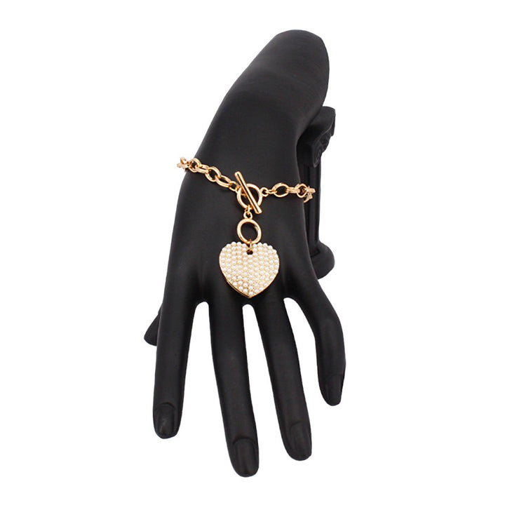 Cream Stone Paved Heart Pendant Metal Toggle Bracelet, is a must-have accessory for any fashion-forward individual. Exquisitely crafted to elevate any outfit, this bracelet is a unique addition to your jewelry collection. Its toggle closure ensures a secure fit and its elegant style will make you stand out from the crowd.