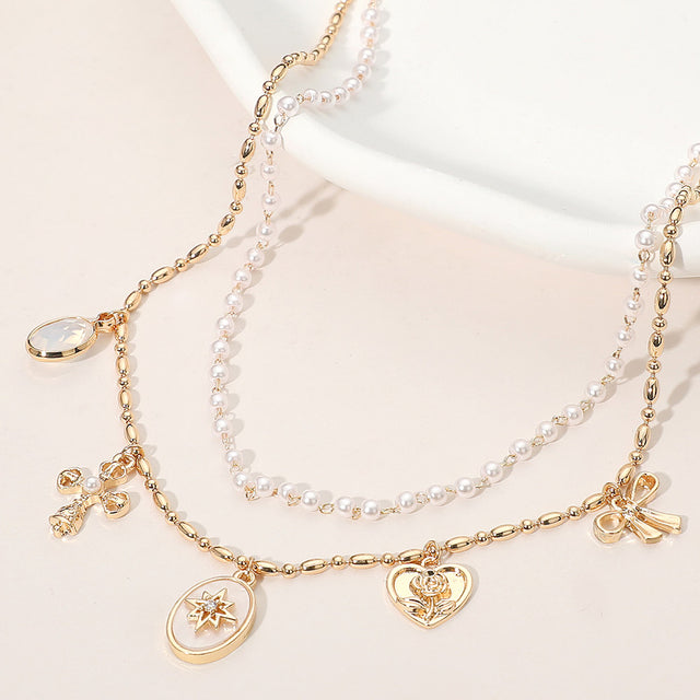 Madeline Love Cream, Gold Cross Floral Heart Bow Charm Station Pearl Layered Necklace
