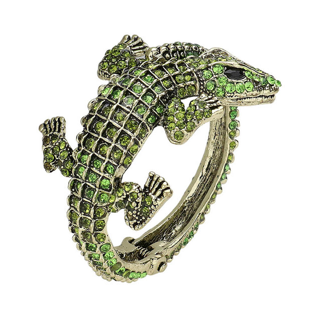 Gold Green Crystal Rhinestone Crocodile Alligator Hinged Cuff Bracelet is a dazzling accessory that adds a touch of glamour to any outfit. Its intricate design and sparkling rhinestones make it a standout piece, while its hinged cuff allows for a comfortable and secure fit. Elevate your style with this stunning bracelet.