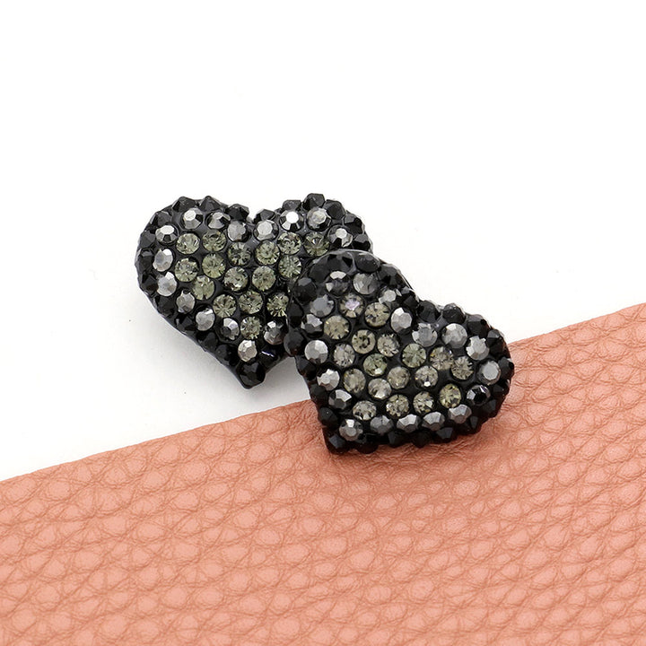 Gold-Jet-Black-Crystal Paved Heart Stud Earrings feature a beautiful, sparkling design that adds elegance and charm to any outfit. Made with high-quality crystals, these earrings are both stylish and durable. Elevate your look with these timeless, sophisticated earrings.