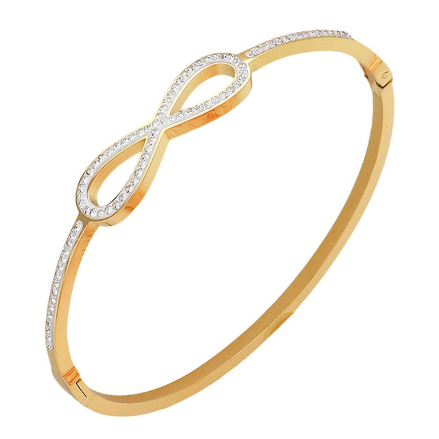 Gold Stainless steel bangle bracelet features a timeless infinity design and is intricately paved with shimmering stones. Made with durable stainless steel, it is both stylish and durable. Elevate your jewellery collection with this versatile and elegant piece that will add a touch of sophistication to any outfit.
