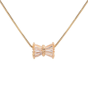 Gold Stone Embellished Ribbon Pendant Necklace features a delicate design and is embellished with sparkling stones. Crafted with quality materials, this necklace is the perfect accessory to elevate any outfit. With its elegant ribbon pendant and timeless look, it is sure to make a statement and add a touch of sophistication