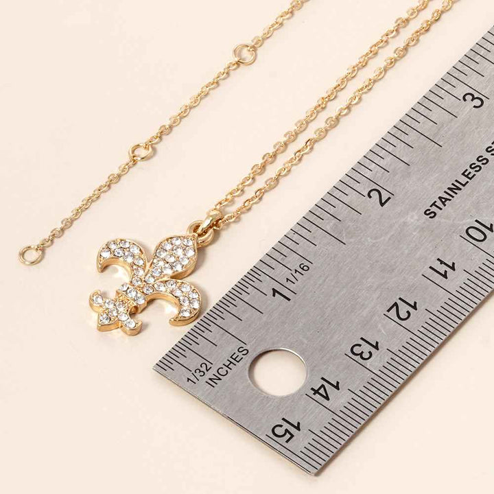 Gold-Stone Paved Fleur de Lis Pendant Necklace are expertly crafted with a unique design and paved with high-quality stones for a stunning effect. This necklace is perfect for adding a touch of elegance and sophistication to any outfit. Enhance your style with this beautiful pendant necklace today. 