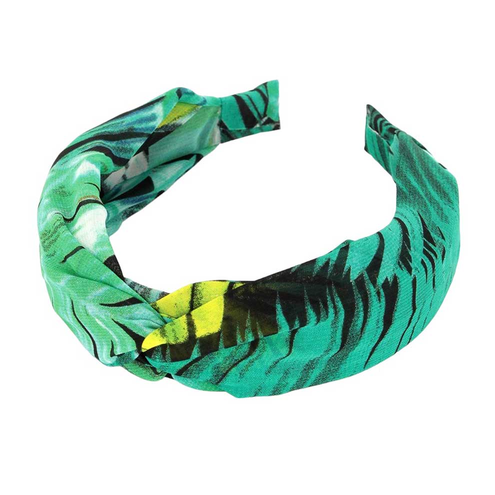 Green Tropical Leaf Patterned Twisted Headband, perfect for adding a touch of summer to any outfit. Crafted with a unique twisted design and featuring a vibrant tropical leaf pattern, this headband is both stylish and functional. Stay on-trend and keep your hair in place with this fashionable accessory.