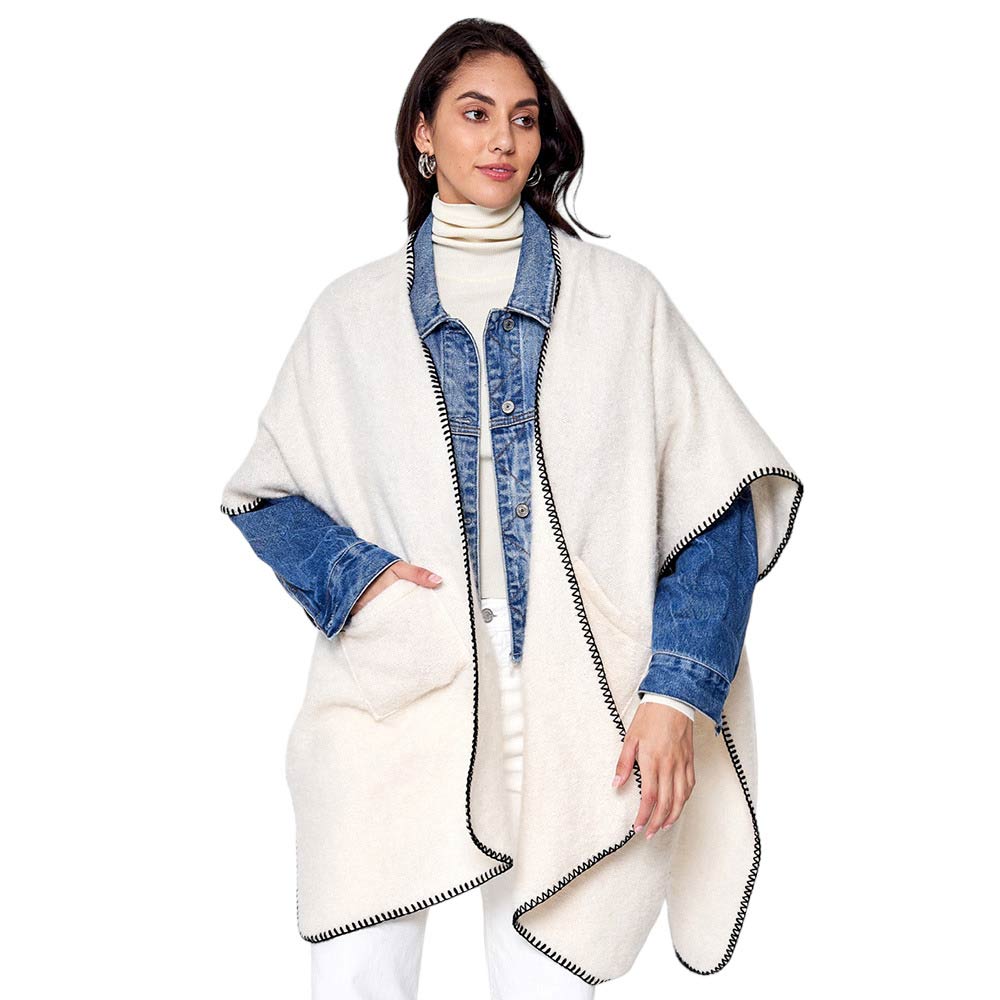 Ivory Blanket Stitch Front Pockets Kimono Poncho, is designed with a stylish blanket stitch detail and two front pockets for added convenience. The poncho is made from soft, breathable fabric and is perfect for everyday wear this winter. Ideal gift for friends and family on chilly winter days. 