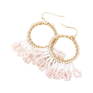 Ivory Seed Beaded Fringe Metallic Tiered Circle Dangle Earrings, Inject some drama into your look with these stunning pieces. Crafted with layers of tiny seed beads and metallic circles, these beautiful earrings provide a unique and eye-catching addition to any outfit. A perfect accessory for any occasion.