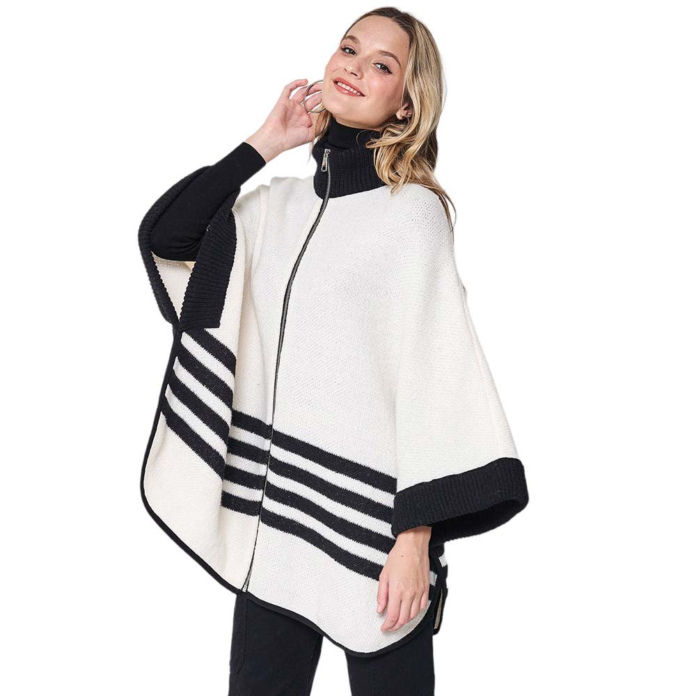 Ivory Sporty Bordered Zip Up Knit Cape Poncho, Crafted with a cozy acrylic-blend fabric, it features a zip-up front and generous hood for extra protection against the cold. The bold, bordered design adds a classic touch, making it the perfect piece for outdoor activities. A Perfect winter gift for any occasion