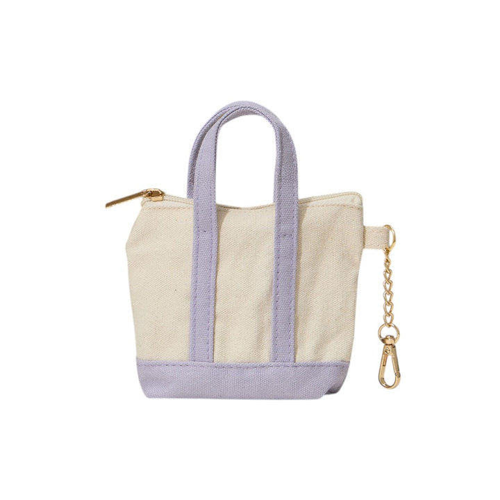 Lavender Mini Canvas Pouch Bag doubles as a chic bag charm, combining style with practicality. Crafted from durable canvas, it offers a compact space perfect for carrying essentials like keys, cards, or small cosmetics. Its lightweight design attaches easily to your handbag, adding a trendy accent while keeping your valuables within reach. Ideal for those who value convenience and a polished look in everyday accessories.