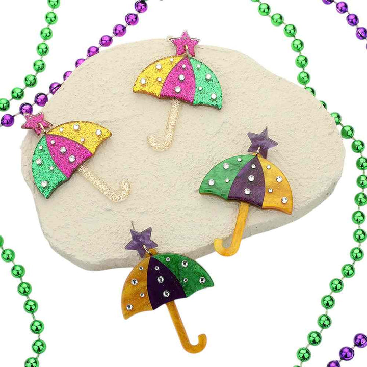 Multi-2-Mardi Gras umbrella earrings are adorned with glittered resin stones, adding a touch of sparkle to your festive look. Made with expert craftsmanship, they are a perfect accessory for any occasion. Let these earrings be the statement piece to elevate your style. 