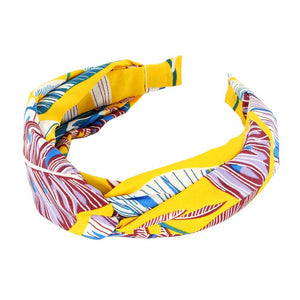 Mustard Tropical Leaf Patterned Twisted Headband, perfect for adding a touch of summer to any outfit. Crafted with a unique twisted design and featuring a vibrant tropical leaf pattern, this headband is both stylish and functional. Stay on-trend and keep your hair in place with this fashionable accessory.