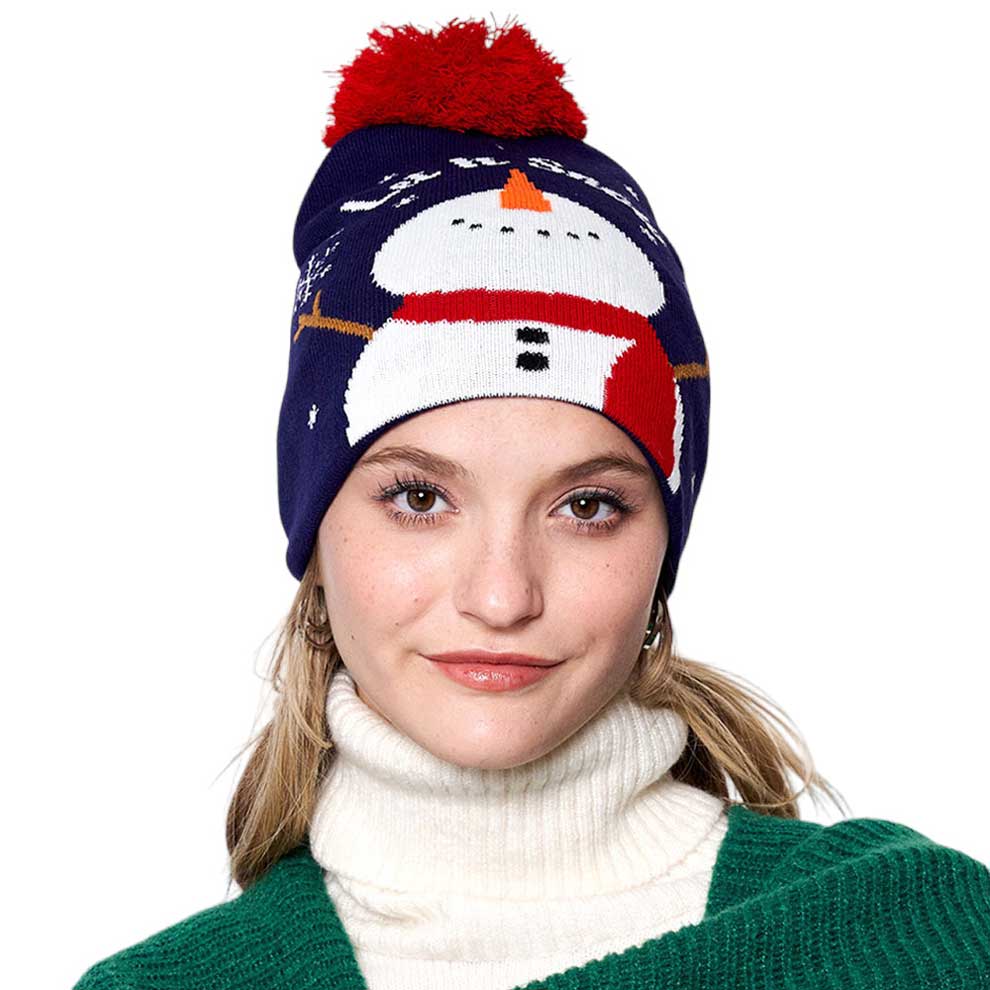 Navy Let it Snow Message Snowman Snowflake Pom Pom Beanie Hat. Stay cozy and stylish this winter season with this. Featuring a festive Christmas theme complete with a snowman, snowflakes, and a luxuriously soft pom pom, this beanie hat is perfect for cold-weather wear. Enjoy the utmost warmth and comfort all winter long.