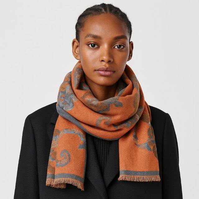 A soft scarf featuring an elegant floral print with a bordered edge and fringe finish. Lightweight yet cozy, this versatile accessory brings warmth and a touch of sophistication to casual and dressy outfits.