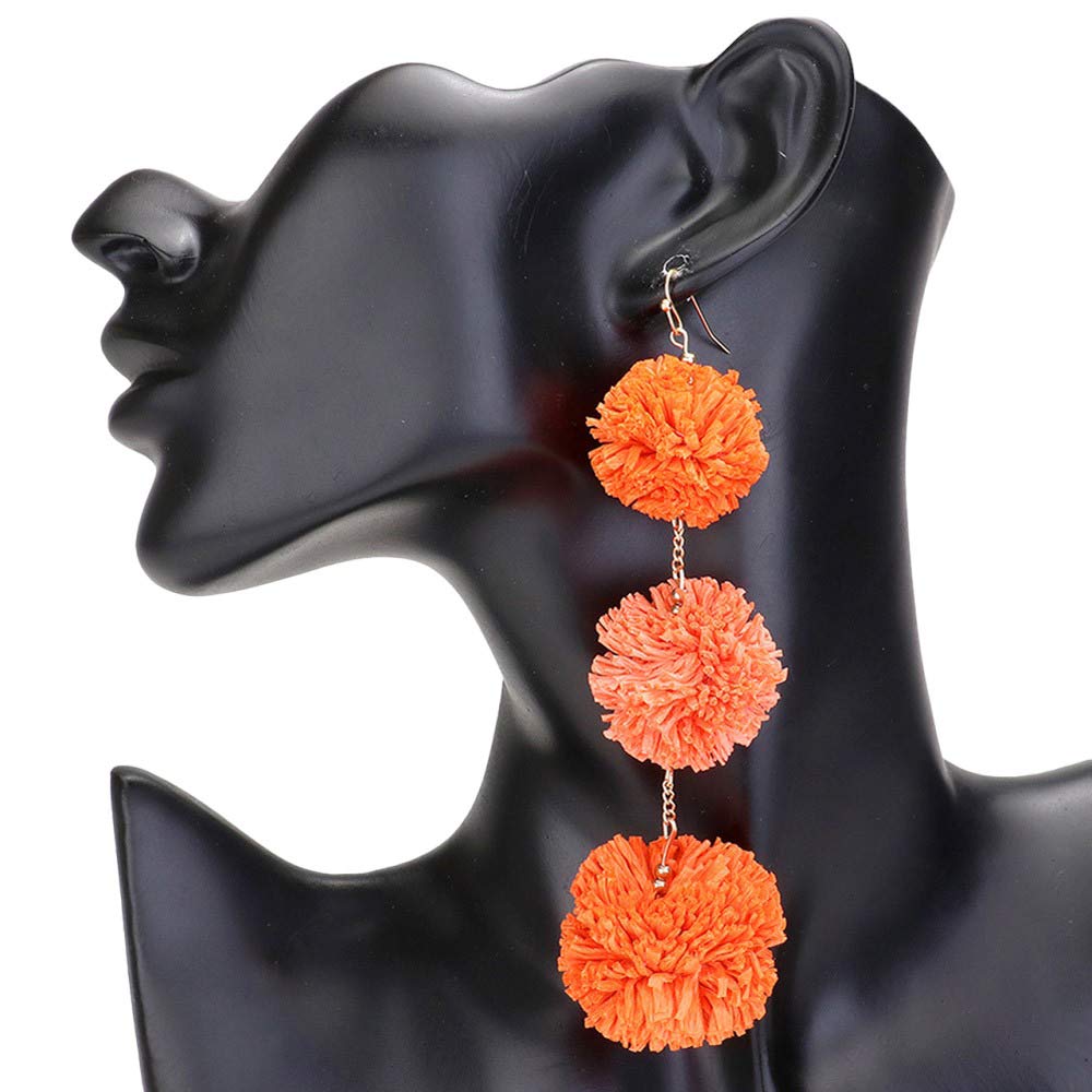 Orange Raffia Pom Pom Link Dropdown Earrings, These unique earrings combine the natural texture of raffia with playful pom poms to add a touch of whimsy to any outfit. The link design gives them a modern, chic feel while the dropdown style elongates the neck. Elevate your style with these statement earrings.