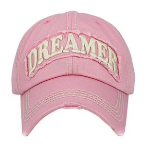 Pink Dreamer Message Vintage Baseball Cap, is crafted from durable cotton twill. It features an adjustable strap with an antique brass buckle for a snug fit and a unique vintage look. The bold printed message displays the wearer's commitment to their dream. Get the perfect fit and stylish look with this one-of-a-kind cap.