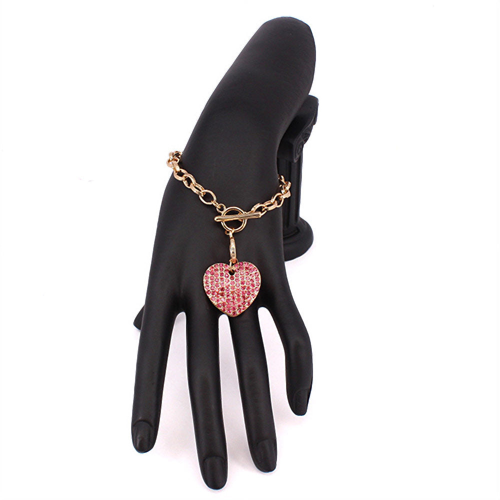 Pink Stone Paved Heart Pendant Metal Toggle Bracelet, is a must-have accessory for any fashion-forward individual. Exquisitely crafted to elevate any outfit, this bracelet is a unique addition to your jewelry collection. Its toggle closure ensures a secure fit and its elegant style will make you stand out from the crowd.