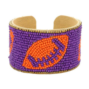Purple Orange Game Day Seed Beaded Football Accented Cuff Bracelet, Show your love for the game with the Game Day Seed Beaded Football Accented Cuff Bracelet. It features a football design accent to create a unique and fashionable look. Perfect for any game day, this bracelet is sure to add a touch of team spirit to your wardrobe. 
