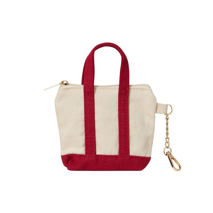 Red Mini Canvas Pouch Bag doubles as a chic bag charm, combining style with practicality. Crafted from durable canvas, it offers a compact space perfect for carrying essentials like keys, cards, or small cosmetics. Its lightweight design attaches easily to your handbag, adding a trendy accent while keeping your valuables within reach. Ideal for those who value convenience and a polished look in everyday accessories.