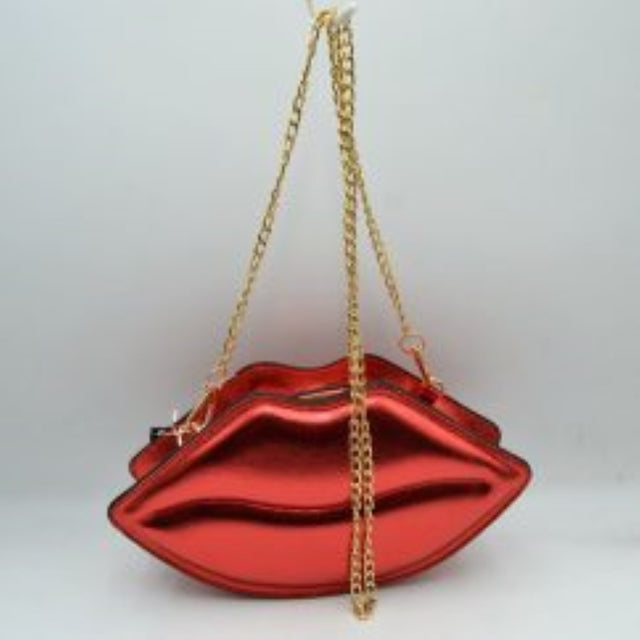 Red This novelty crossbody bag features a unique lip-shaped design with a high-shine metallic finish that adds a playful statement to any ensemble. Designed for everyday use or special occasions, it features a secure top zipper closure to keep small essentials protected while on the go. Equipped with a long, metallic chain-link shoulder strap that attaches via sturdy clasps, this eye-catching accessory offers convenient and stylish hands-free carrying.
