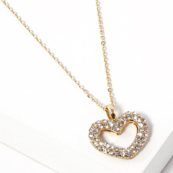 Rhinestone Embellished Open Heart Pendant Necklace is the perfect accessory for adding a touch of glamour to any outfit. Featuring sparkling rhinestones and a dainty open-heart pendant, this necklace exudes elegance and sophistication. With its versatile design, it can be worn for any occasion and is sure to make a statement. Elevate your style with this stunning piece.