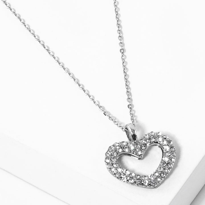 Rhinestone Embellished Open Heart Pendant Necklace is the perfect accessory for adding a touch of glamour to any outfit. Featuring sparkling rhinestones and a dainty open-heart pendant, this necklace exudes elegance and sophistication. With its versatile design, it can be worn for any occasion and is sure to make a statement. Elevate your style with this stunning piece.