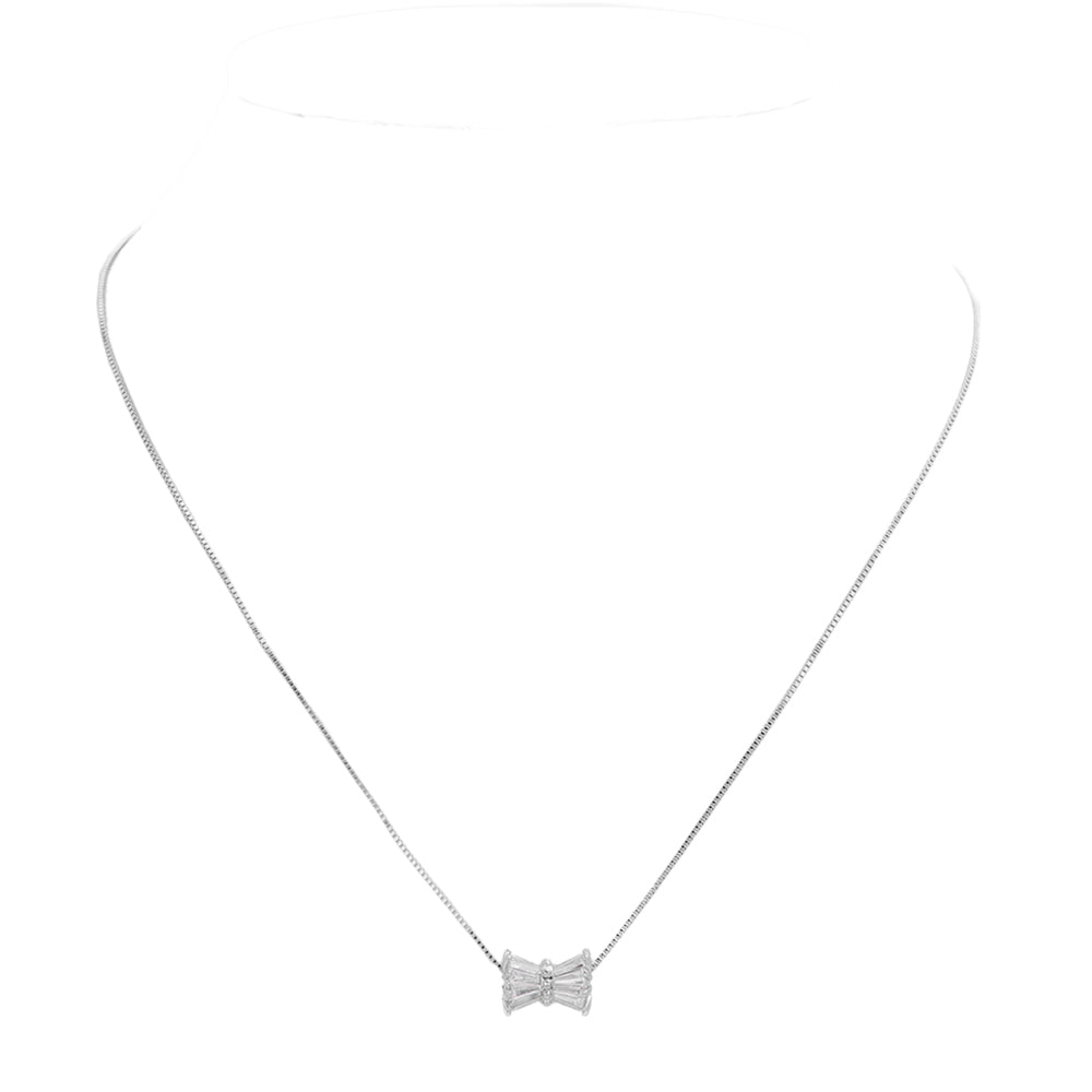 Rhodium Stone Embellished Ribbon Pendant Necklace features a delicate design and is embellished with sparkling stones. Crafted with quality materials, this necklace is the perfect accessory to elevate any outfit. With its elegant ribbon pendant and timeless look, it is sure to make a statement and add a touch of sophistication