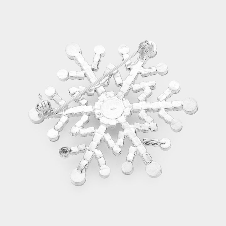 Elegant snowflake brooch pin adorned with sparkling rhinestones in a dazzling winter design. Perfect accessory for coats, scarves, and holiday outfits, adding festive sparkle and seasonal charm to any look. A perfect gift for Christmas.