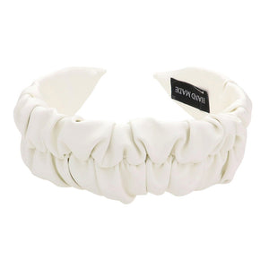 White Pleated Solid Faux Leather Headband, This stylish accessory adds an elegant touch to any outfit. Made with high-quality materials, it is both comfortable and durable. The pleated design offers a unique, sophisticated look, while the faux leather adds a touch of luxury. Perfect for any formal or casual occasion wear.