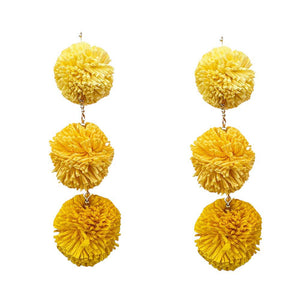 Yellow Raffia Pom Pom Link Dropdown Earrings, These unique earrings combine the natural texture of raffia with playful pom poms to add a touch of whimsy to any outfit. The link design gives them a modern, chic feel while the dropdown style elongates the neck. Elevate your style with these statement earrings.